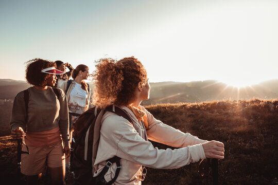 Group of friends hiking a mountain ridge at sunset