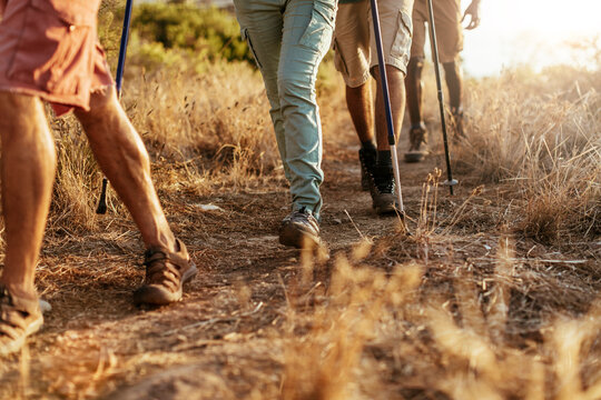 Group of hikers on dusty nature trail at sunset