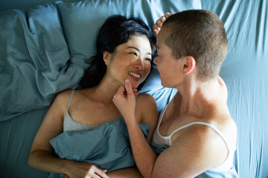 Affectionate couple cuddling in bed at home