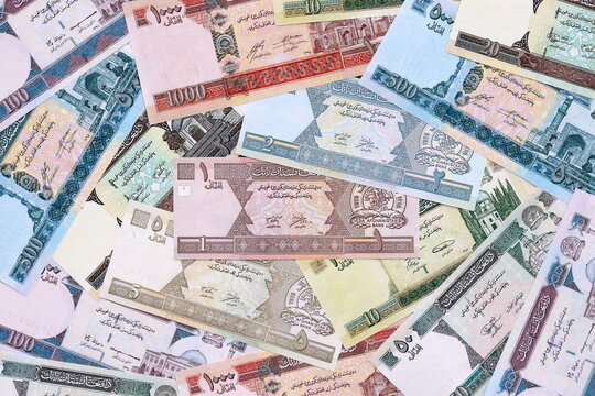 Afghan afghani money bills pile on table. Afghanistan banknotes of AFN currency close up.