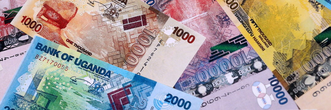 Ugandan shilling money bills pile on table. Uganda banknotes of UGX currency close up.