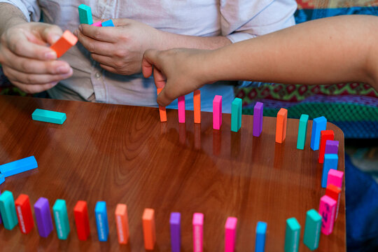 Hispanic father and son setting up colorful blocks.