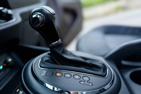 Automatic transmission gear shift stick in a modern car luxury interior. Close up of automatic gear selector lever. Car gearbox handle with parking position illuminated.