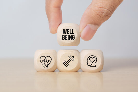 Employee wellbeing concept. Wooden blocks with physical, mental, emotional health icons. Creating employee benefits, satisfaction programs. Fostering positive work culture, employee engagement