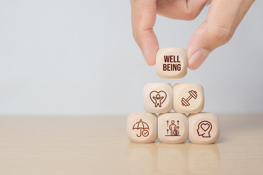 Employee wellbeing concept. Hand hold wooden blocks with physical, mental, emotional health icons. Creating employee benefits. Fostering positive work culture, employee engagement