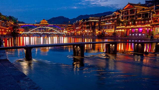 Night scenery of Tuojiang River in Fenghuang Ancient Town, ancient bridge, folk houses and light water reflections