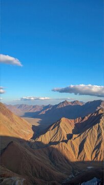 Hazy blue sky over rocky desert landscape with red mountains