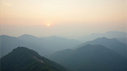 Naklejka premium A tranquil scene with the sun rising over a mountain range, creating a serene and picturesque landscape.