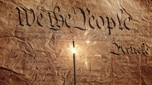 Lit sparkler over US American declaration of independence showing We The People on parchment. For United States of America Independence Day on the 4th of July or other patriotic USA celebrations. Loop