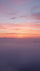 Fototapeta premium Pink and purple hues of sunset above foggy valley