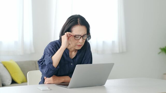 メガネを外してパソコンを見る女性