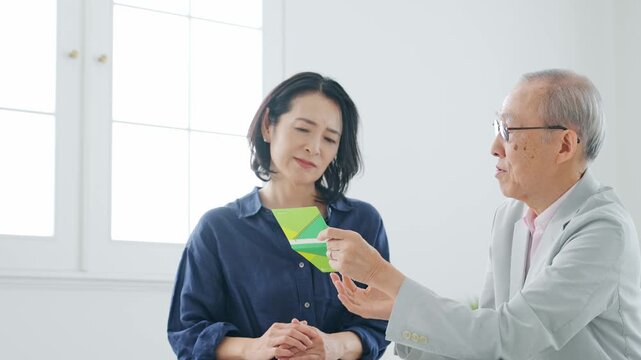 通帳を見ながら相談する女性とシニア男性