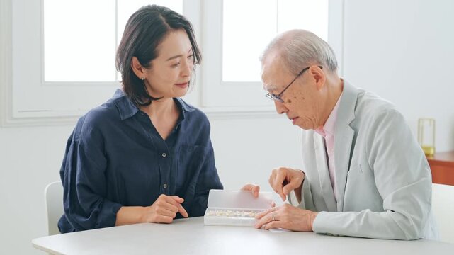 高齢男性に薬を説明する女性