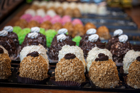 A tempting array of confections in a Bruges bakery, showcasing Belgium's rich dessert culture with colorful, textured treats.