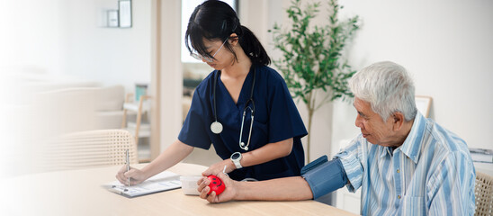 Fototapeta premium Asian elderly man receiving healthcare checkup from female nurse at home, showing senior care, medical support, wellness, and aging lifestyle.