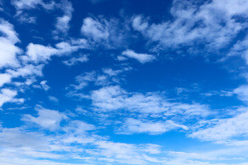 Naklejka premium Bright blue sky with scattered white clouds on a sunny day