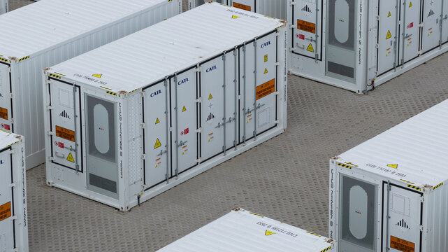 Dronten, Netherlands - 04 April 2026: Aerial view of white CATL battery storage containers arranged on a paved industrial site.