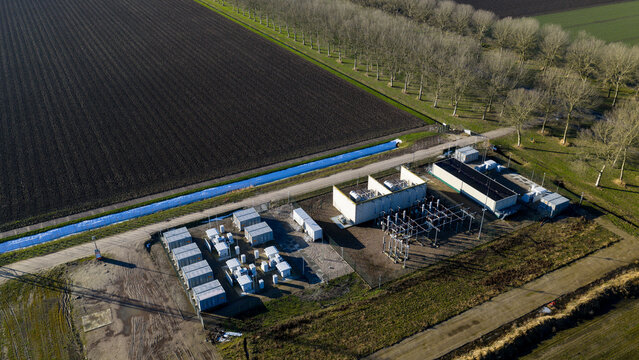 Zeewolde, Netherlands - 14 January 2026: Aerial view of an electrical substation and battery storage facility with white containers and power infrastructure next to agricultural fields.