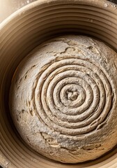 Fototapeta premium A potter skillfully spins a large, round loaf of dough on a pottery wheel. The dough displays prominent, swirling patterns, revealing its airy interior.