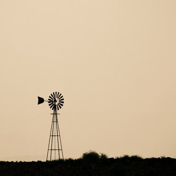 Solitary Windmill Towering Against Endless Dunes, Whispering Stories of Resilience and Solitude in Golden Hour Light