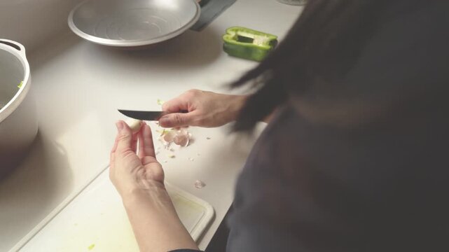 Woman peeling a clove of garlic