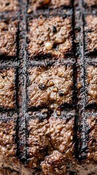 Closeup of grilled beef steak with char marks and seasoning