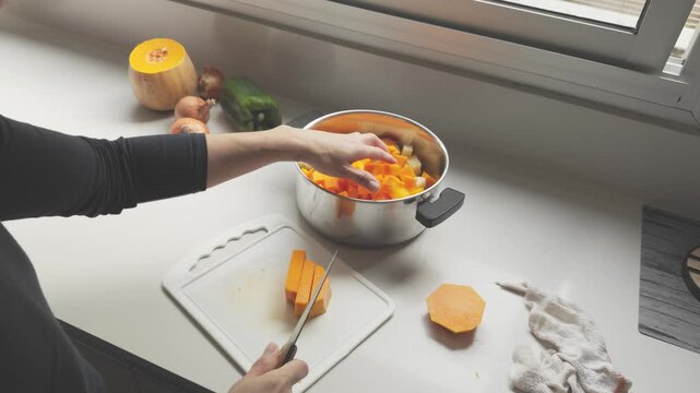 Chef cutting butternut squash preparing vegetable soup