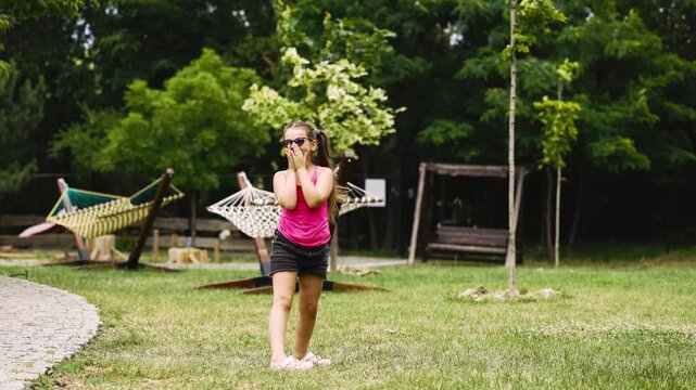 Happy child enjoying frisbee game outdoors surrounded by greenery. Concept healthy lifestyle, happiness and carefree childhood.
