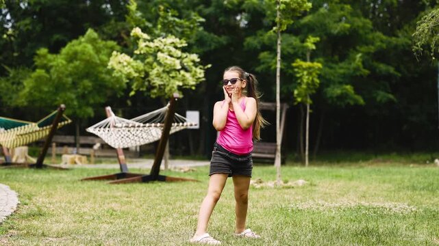 Joyful child playing frisbee in a green outdoor setting surrounded by nature. Concept carefree childhood, wellness and outdoor lifestyle.

