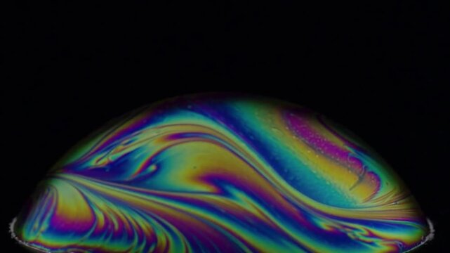 Beautiful Iridescent Soap Bubble Macrophotography Showing Rainbow Interference Patterns on Black