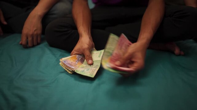 Hands Counting Indonesian Rupiah Banknotes
