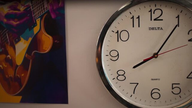 Wall Clock Showing 8 O'Clock Beside Guitar Poster
