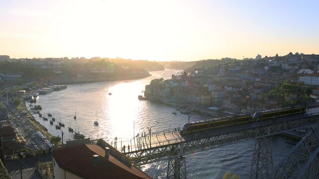 Metro train crossing Dom Luis I Bridge in Porto at sunset