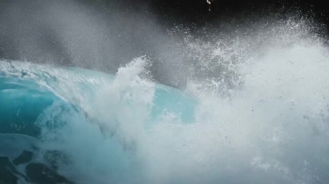 Powerful ocean wave curling and crashing against a dark background