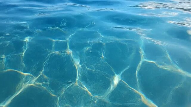 Sunlight reflecting on clear blue water surface