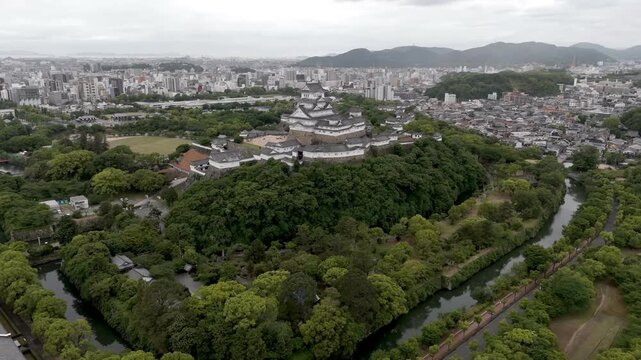 Aerial Approach to Himeji Castle Above Historic Moat and Urban Skyline in Hyogo Japan