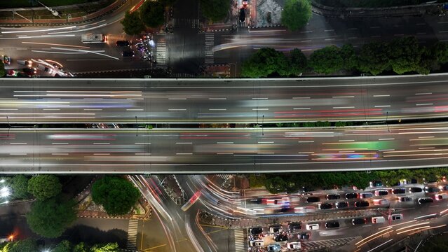 Cilandak, Indonesia - 10 April 2026: Aerial view of the Lebak Bulus overpass at night with vibrant light trails from moving traffic and urban street lights.
