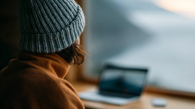 Person with a blue knit cap stares outside