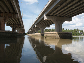 Fototapeta premium Concrete bridges extending over the water, spanning canals and supported by pylons, are essential structures in Thailand.