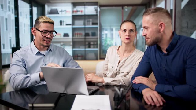 Couple In Estate Agent Office Looking At House Details