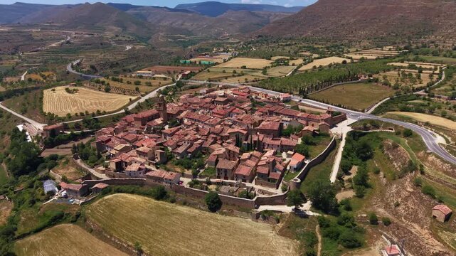 Overhead view of Mirambel, a medieval walled village in Maestrazgo, Teruel, Aragon, Spain, with intact 13th century stone perimeter walls enclosing terracotta rooftops and narrow streets