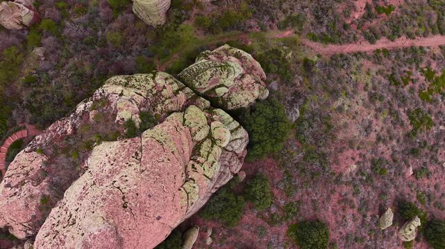 Overhead view of weathered red sandstone rock formations covered in lichen amid sparse vegetation in the mountains of Aragon, Spain