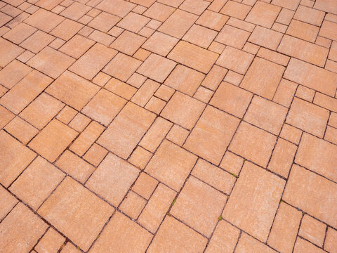 Pattern of interlocking paving stones forming a geometric surface. Durable outdoor pavement texture suitable for architecture, landscaping and construction themes.