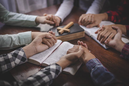 Believers holding hands in prayer during Bible study. Christian faith, hope, unity, worship, fellowship, support, and spiritual growth in a religious gathering.