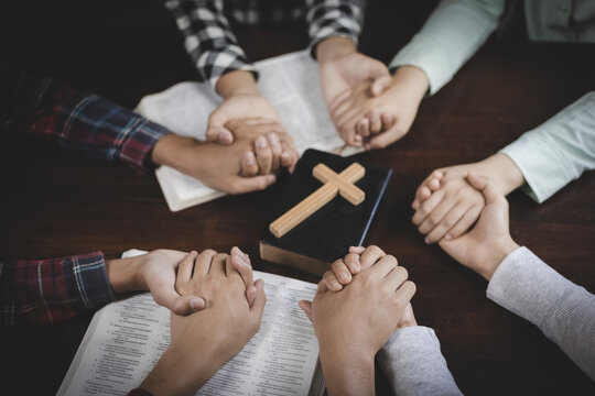 Group prayer and Bible fellowship with hands joined together. Religion, Christian worship, trust, community, devotion, teamwork, and spiritual connection among believers.