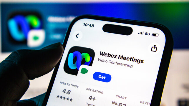 Closeup of a hand holding a smartphone displaying the webex meetings app on the apple app store