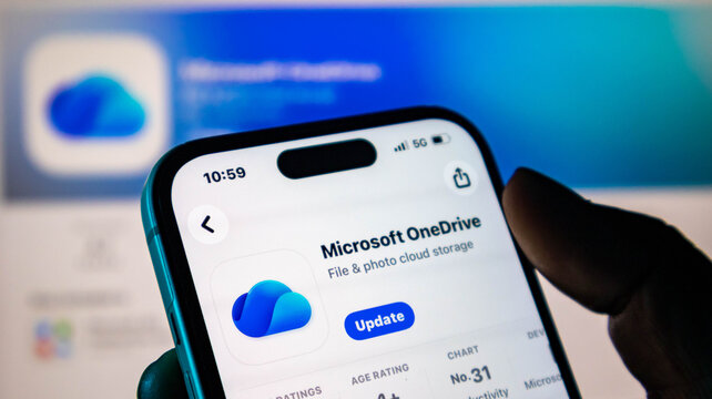 Closeup of a hand holding a smartphone showing the microsoft onedrive app update screen in the apple app store