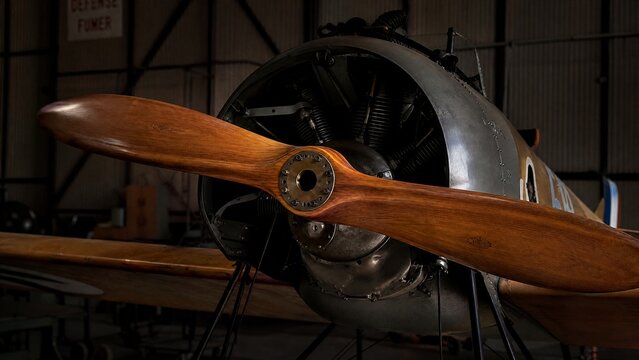 monoplane. The wooden propeller of a vintage monoplane in a quiet hangar. mobility guides, transit brochures, designed for mobility and urban transit guides, improves user orientation.