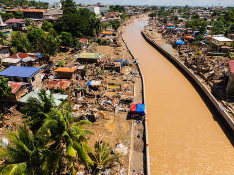 Talisay, Philippines - 11 November 2025: Aerial view of the aftermath of severe flooding along a muddy river with destroyed houses, debris, and silt covering the residential landscape.