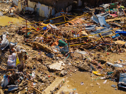 Talisay, Philippines - 11 November 2025: Aerial view of extensive debris and destroyed houses after a natural disaster with scattered corrugated metal and mud.